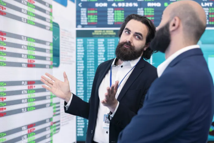 Értékpapírosítás: jelentése, működése és kockázatai Üzletemberek beszélgetnek